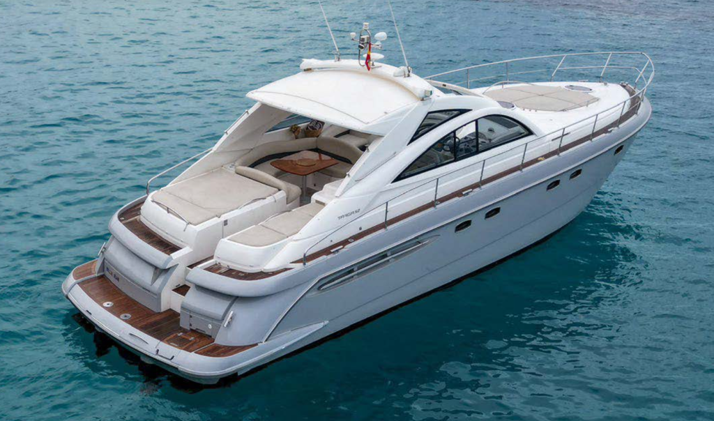 Luftaufnahme einer luxuriösen weißen Motoryacht, die auf ruhigem, blauem Wasser kreuzt und über geräumige Sitzbereiche, ein elegantes, geschwungenes Design sowie eine Badeplattform aus Teakholz am Heck verfügt.